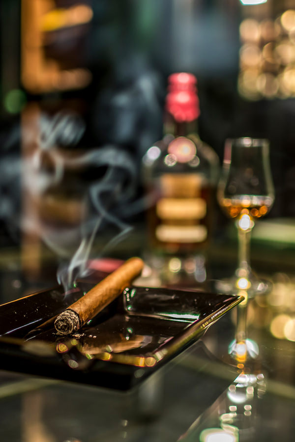 Zigarre und Whisky auf einem Glastisch