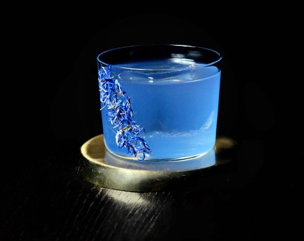 Blauer Cocktail mit Blütenblättern